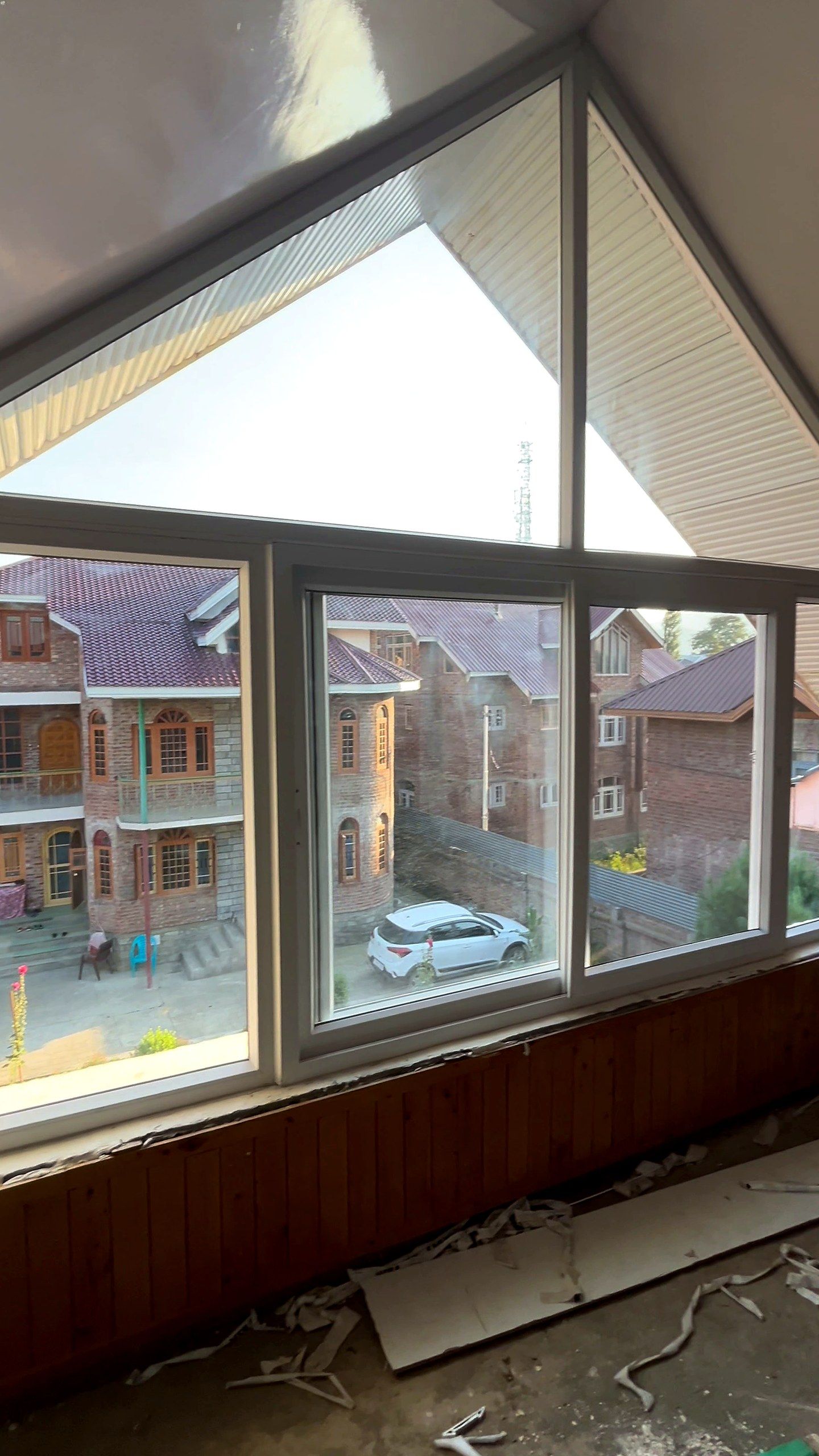 Gable glazing with fixed panes and opening sashes looking over Kashmiri houses