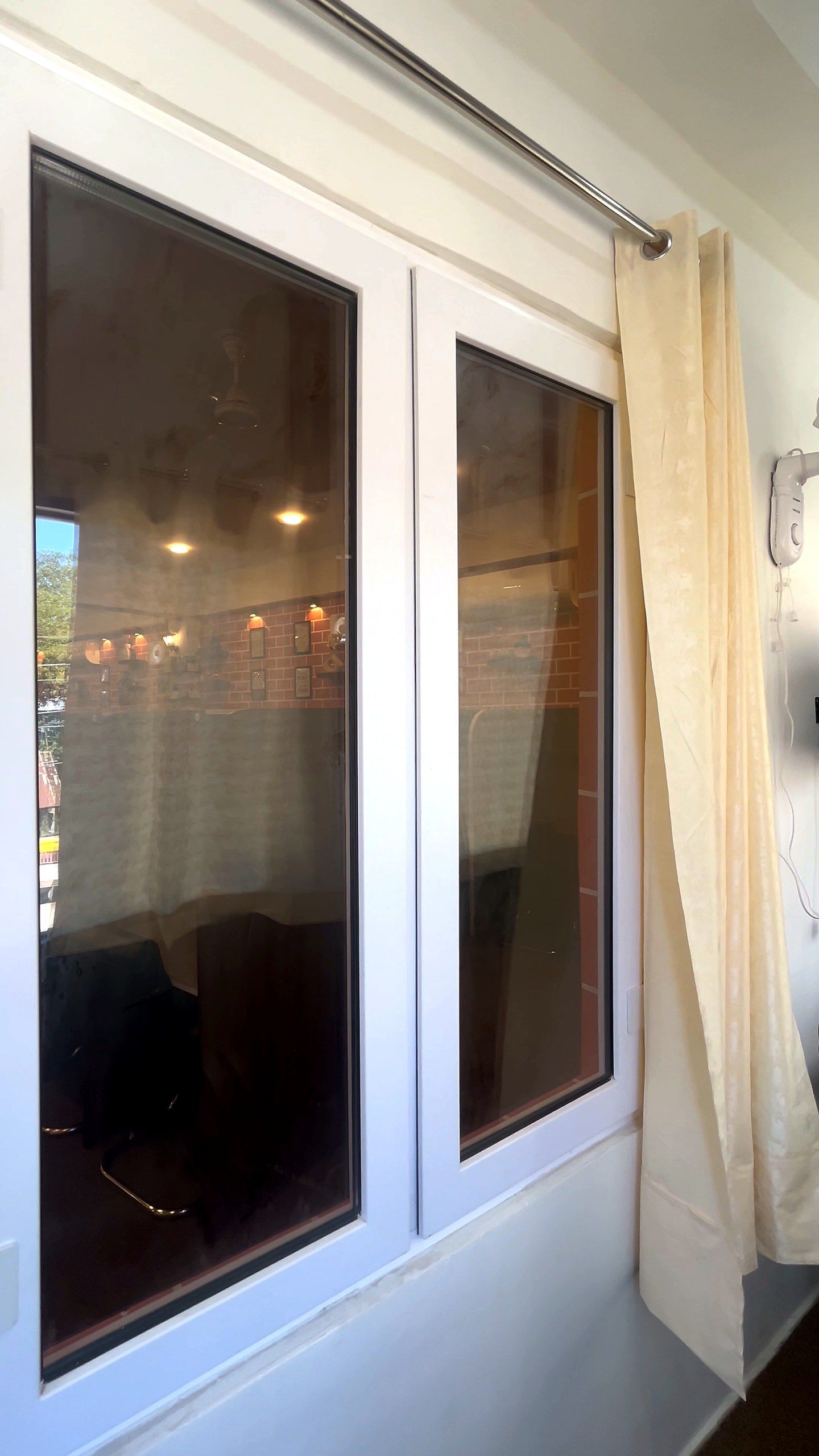 White uPVC windows beside a cream curtain