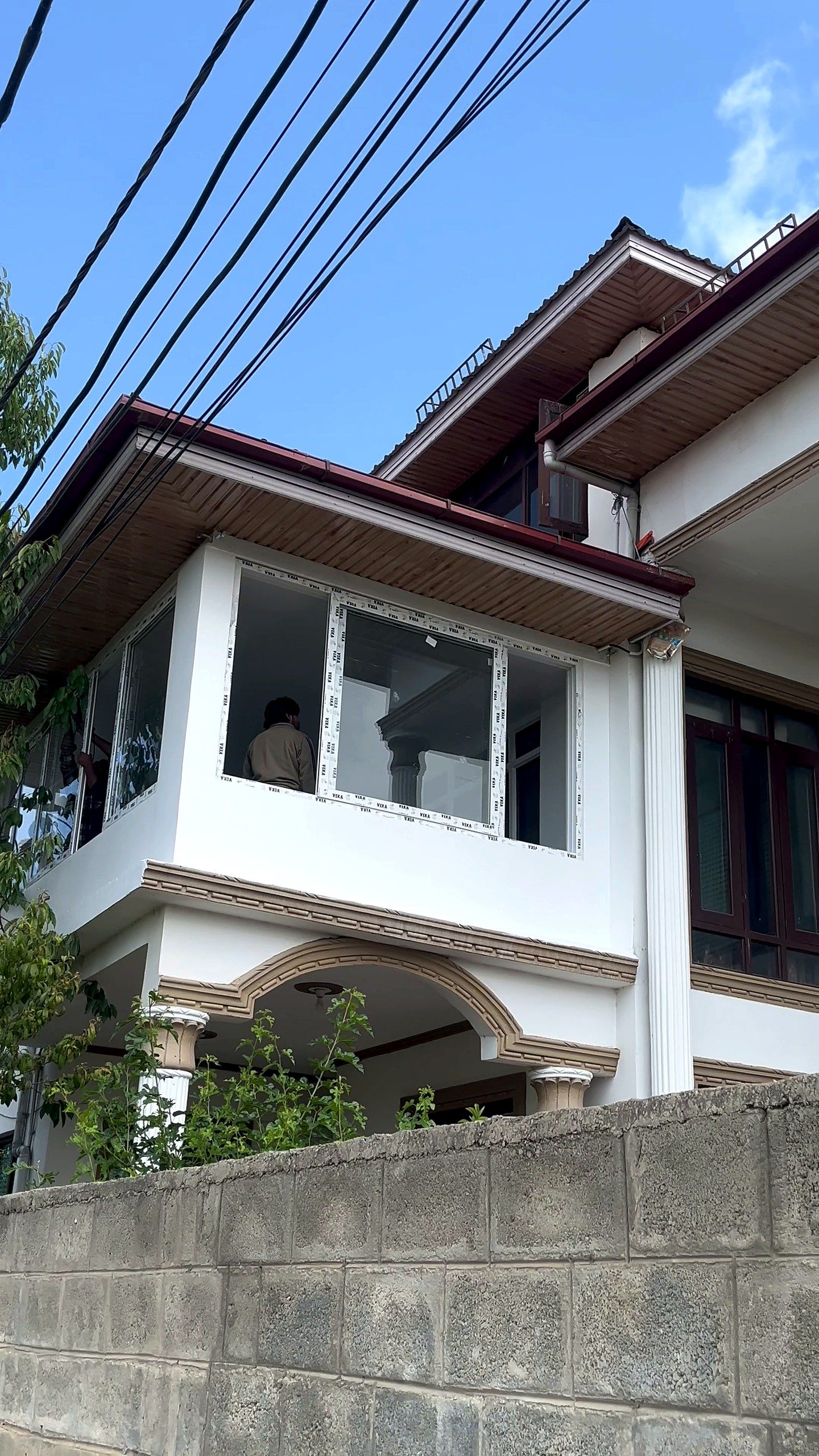 Corner uPVC windows wrapping the top floor of a white Kashmir house