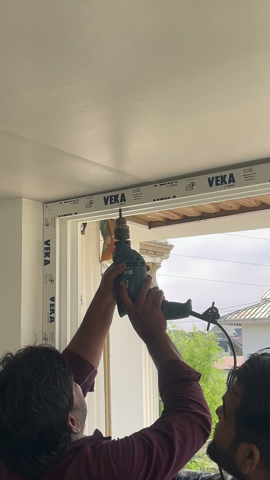Drilling to fix a VEKA frame to the wall