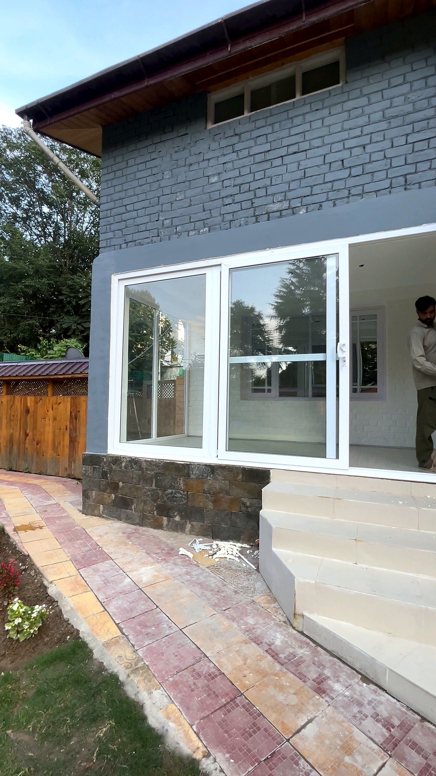 Large uPVC window on a grey house above stone steps
