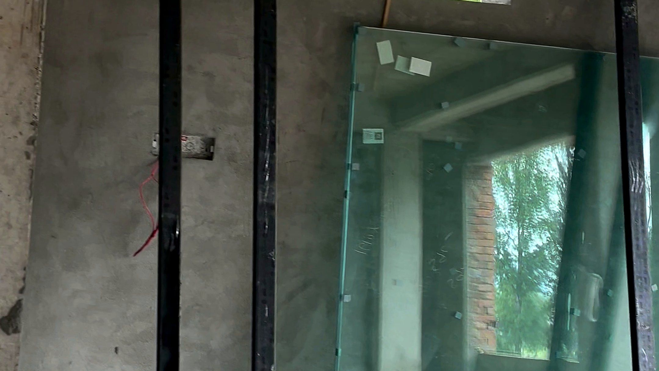 A new uPVC frame and glass ready to fit in a concrete house under construction