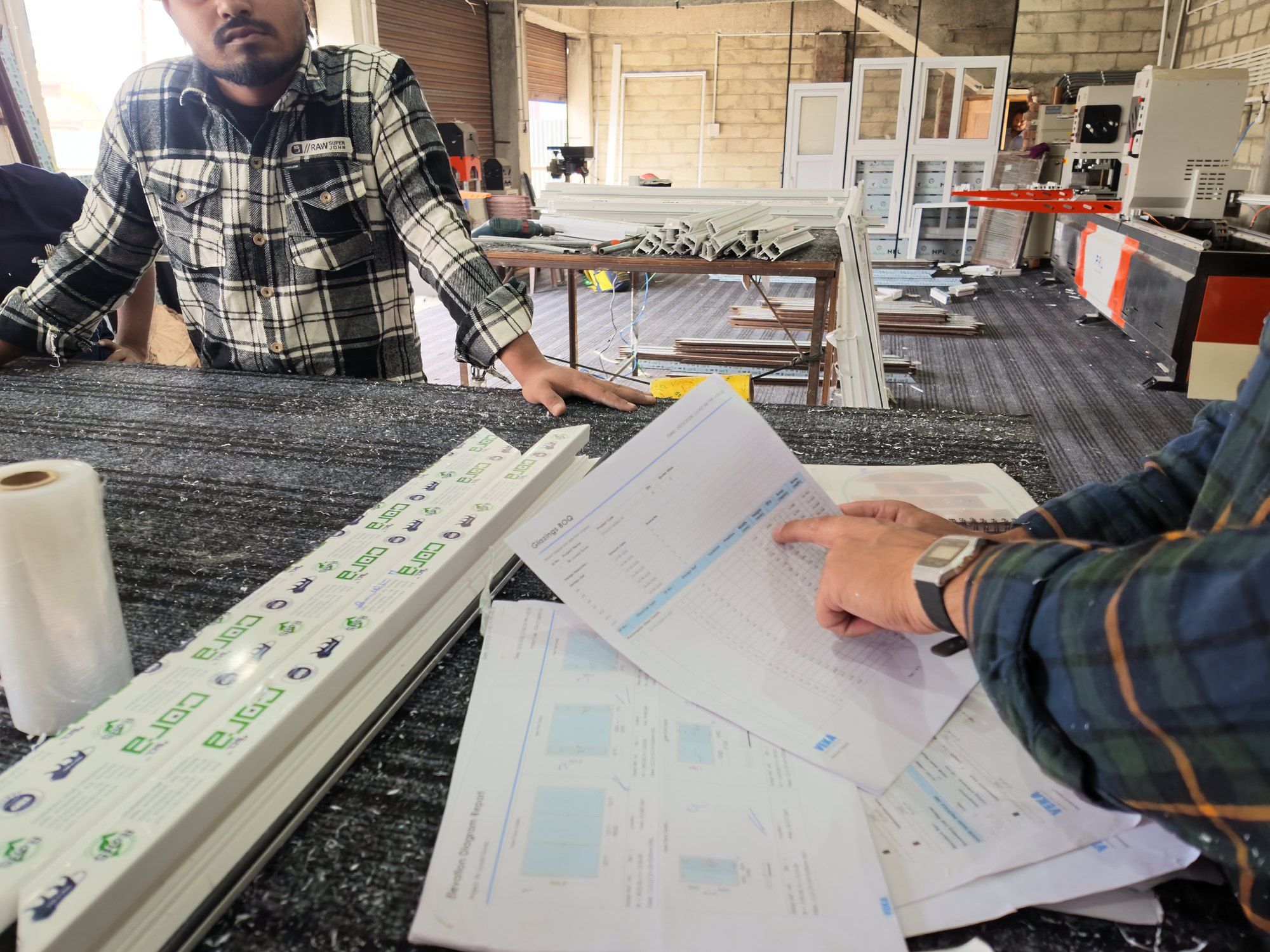 Team checking cutting lists against drawings