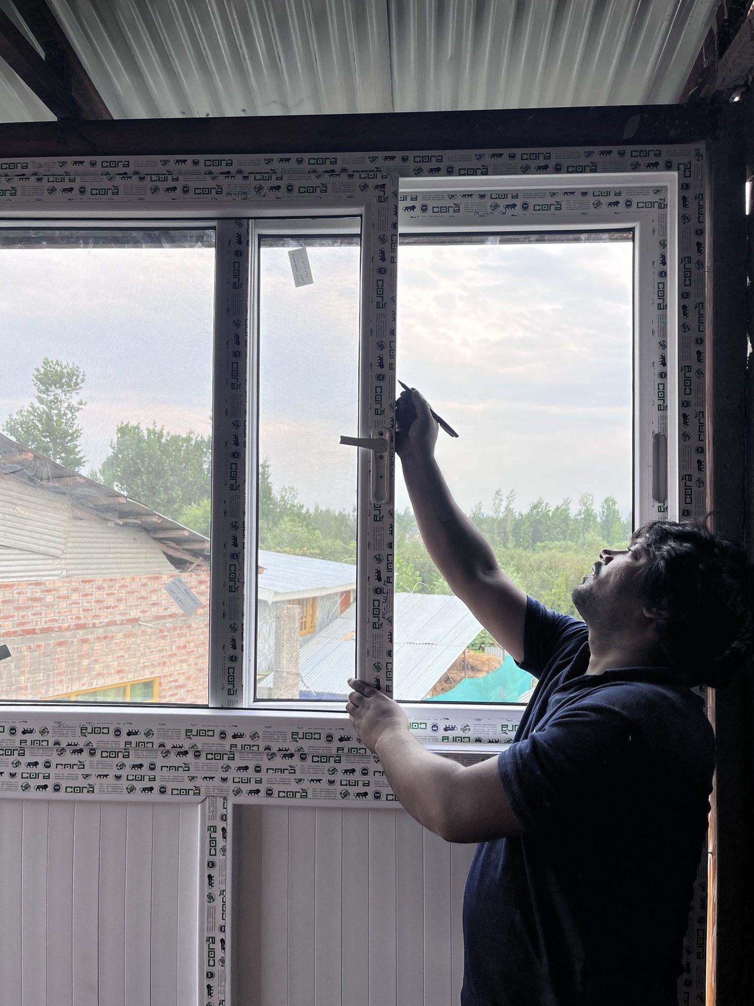 Standard Fabtech measuring a window opening on site with a tape