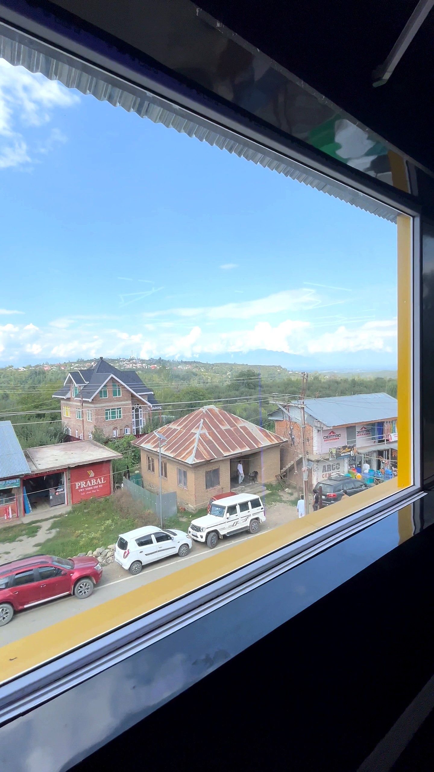 Wide window looking over a town towards the mountains