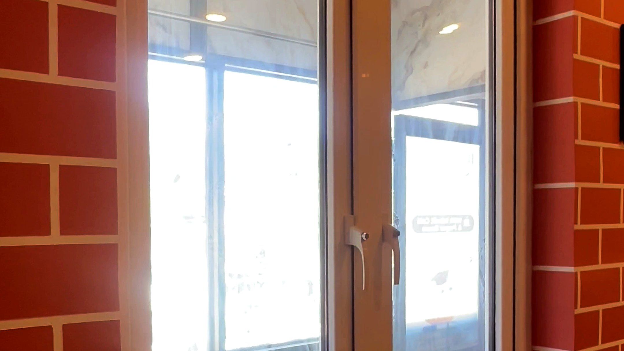 Woodgrain uPVC casement windows in a brick-finish room