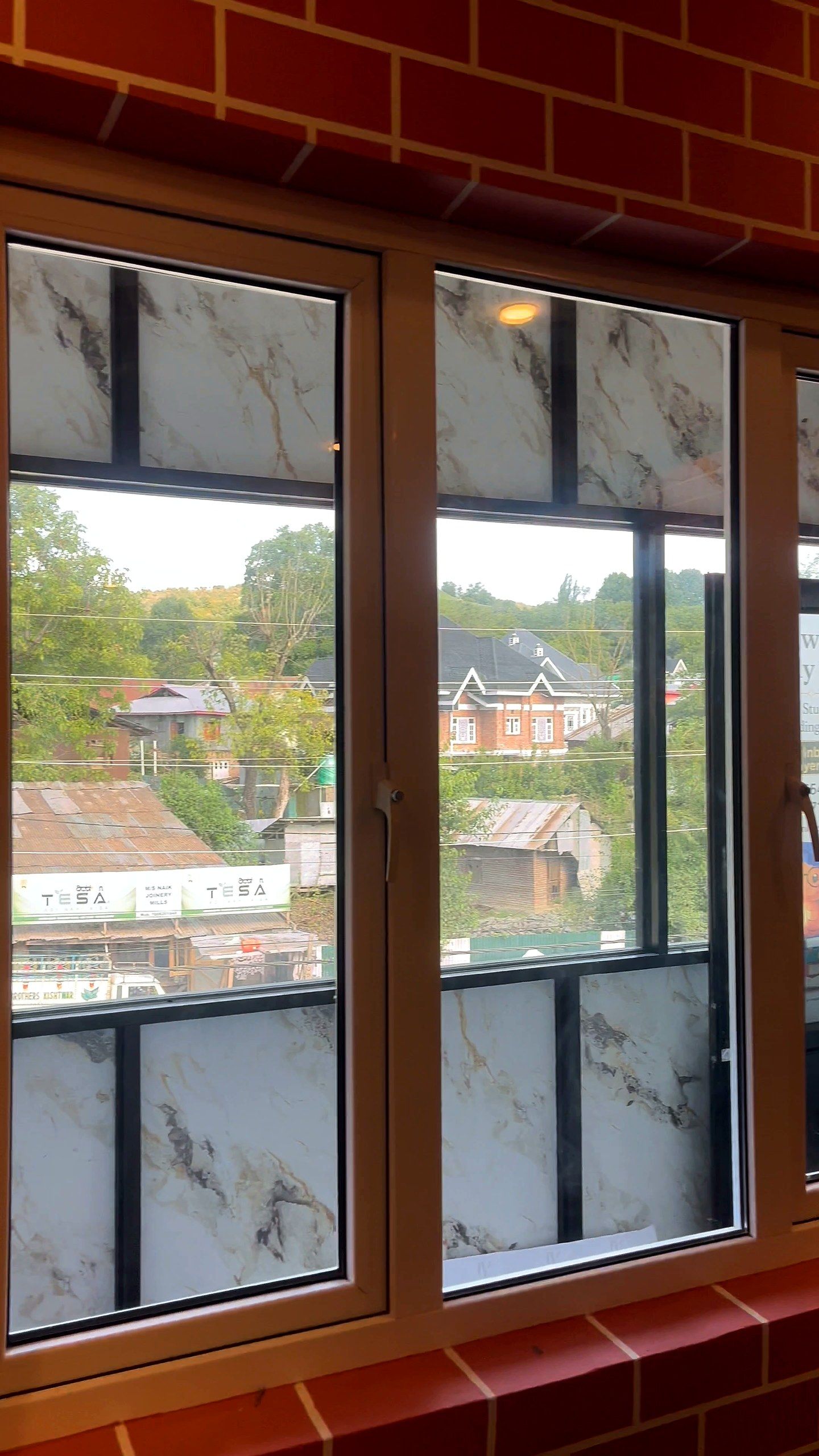 Golden oak woodgrain uPVC window in a brick-finish wall